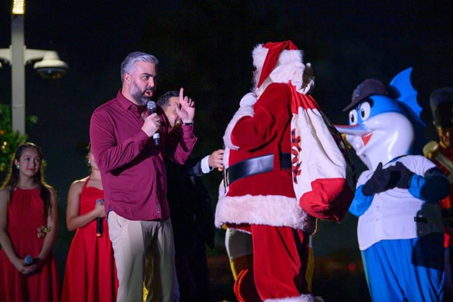 Papá Noel con camisa roja dirigiéndose a una multitud