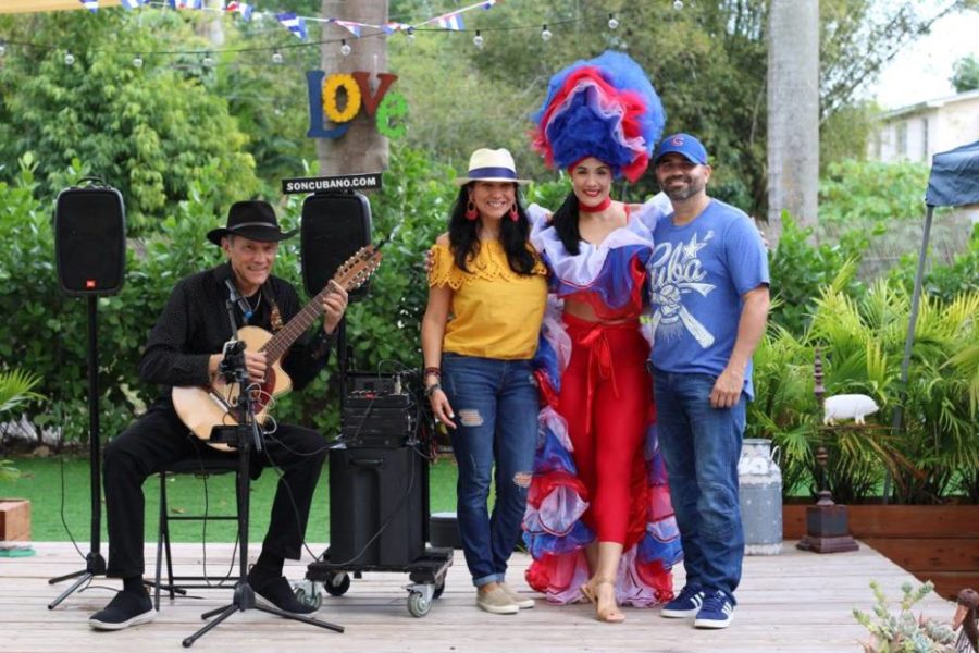 Three people in costume posing for a photo with a guitar