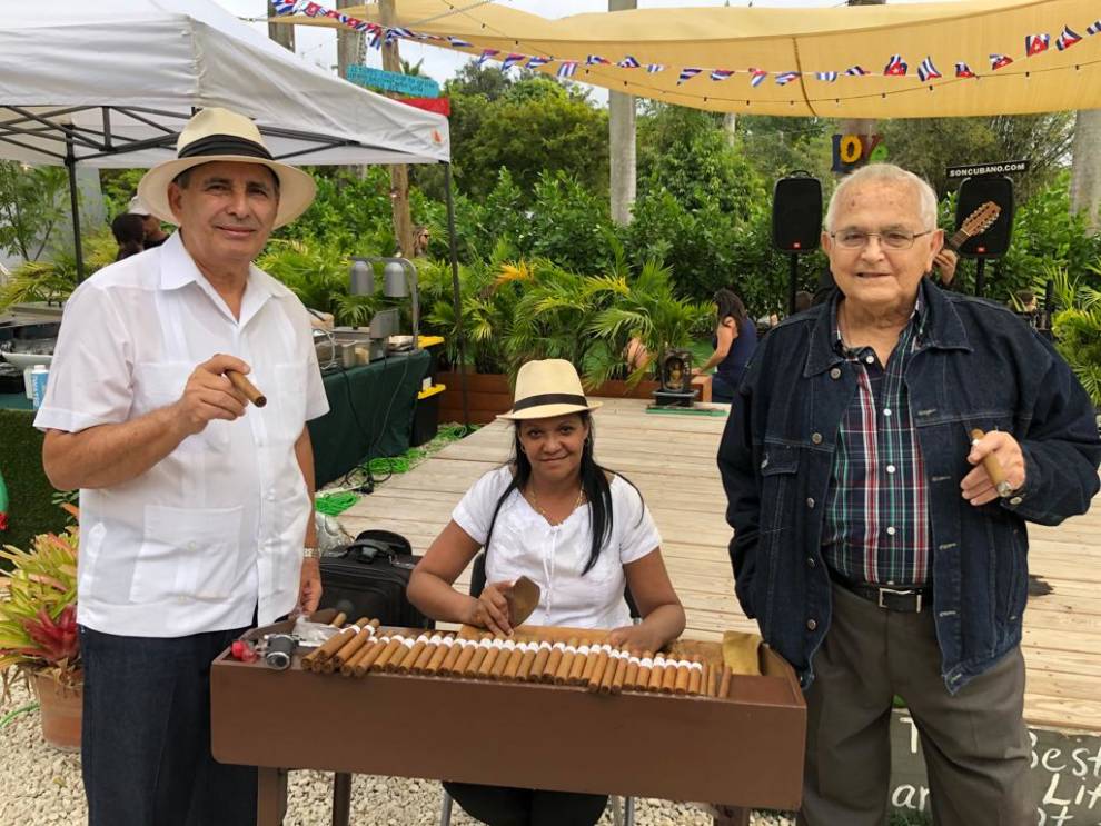 Tres personas tocando música alrededor de una mesa.
