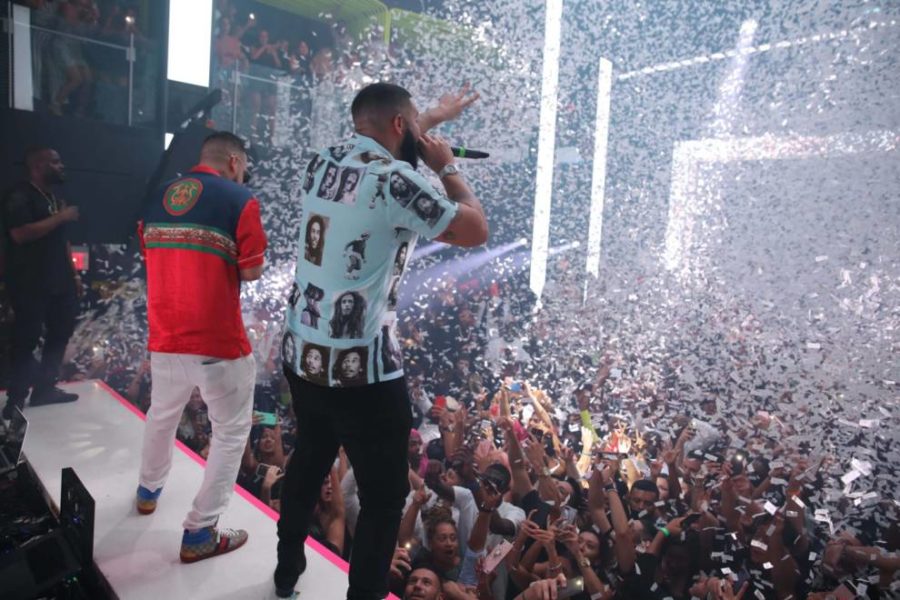Two men on stage, celebrating with confetti raining down from the ceiling