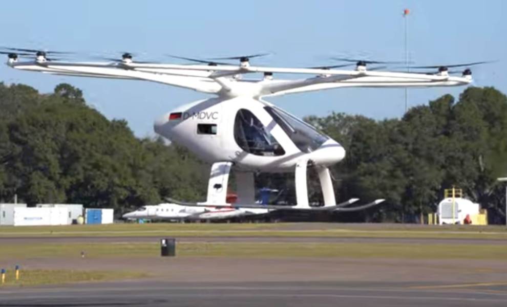 Un pequeño helicóptero blanco está estacionado en la pista.