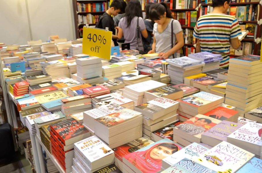 Una mesa llena de libros de varios tamaños y colores, creando una cautivadora muestra de conocimientos y tesoros literarios.