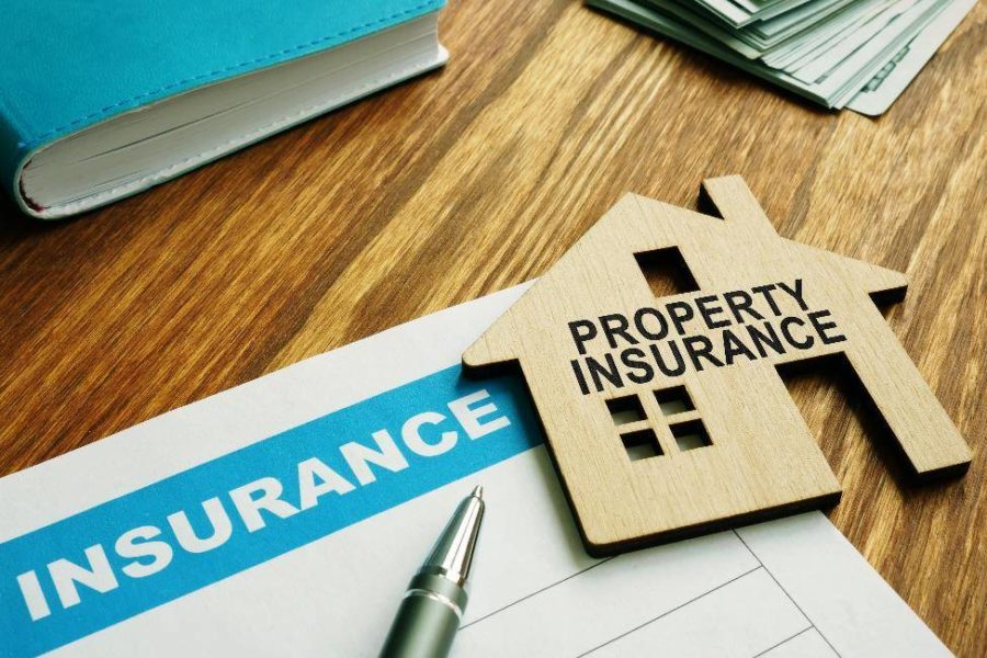 Property insurance papers with a wooden model home