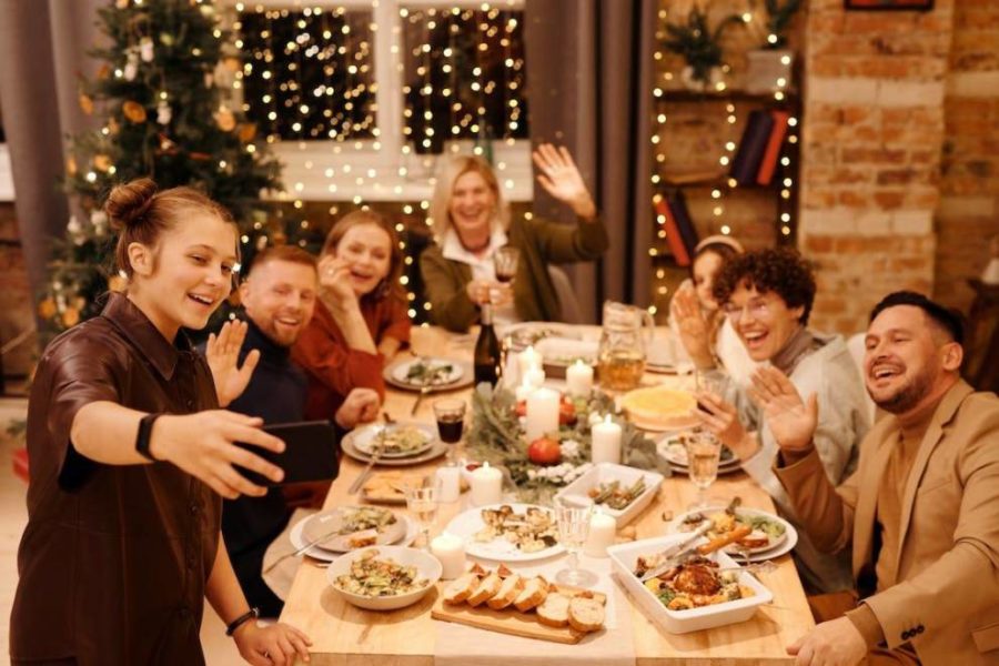 Una familia celebrando la Navidad y tomándose una selfie durante la cena.