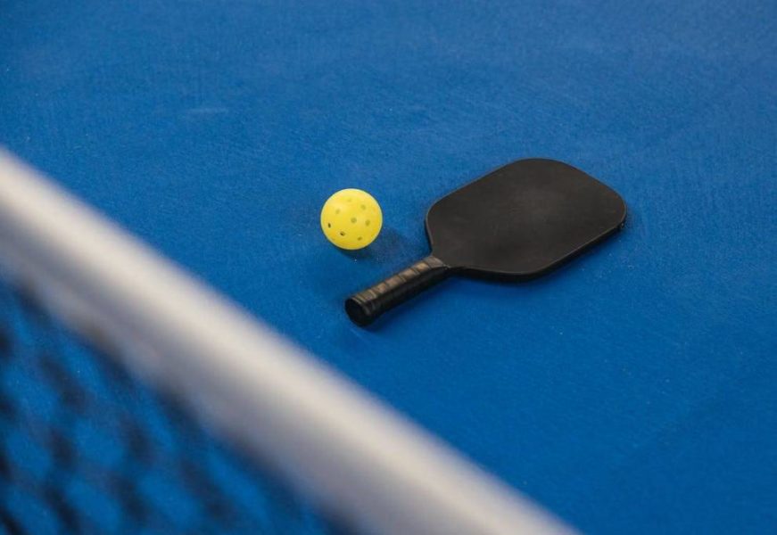 A paddle and ball on the pickleball court
