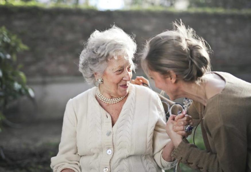 dos mujeres adultas paradas una al lado de la otra, sonriendo, representando la amistad y la unión