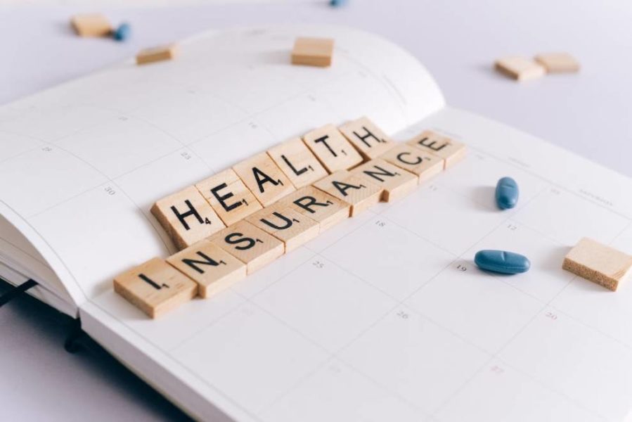 Health insurance concept with Scrabble tiles on a planner, symbolizing planning and coverage for health insurance.