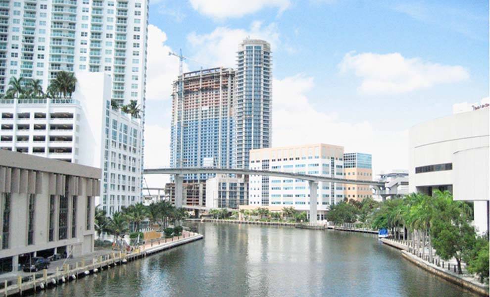 A canal with a bridge in front of towering buildings