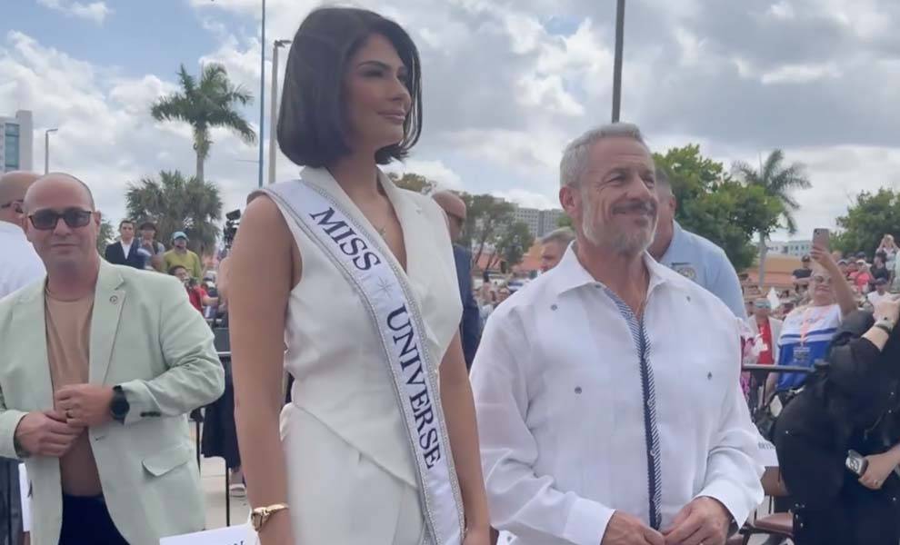 Miss universe poses for a picture with a man