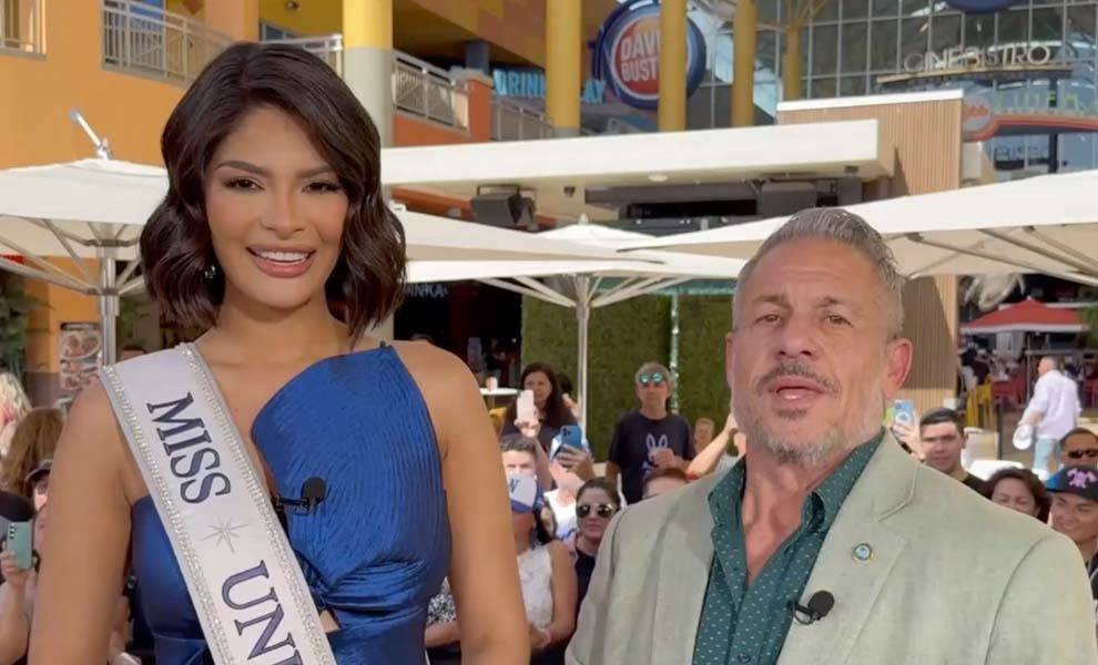 Miss universo posando para una foto con un hombre de traje