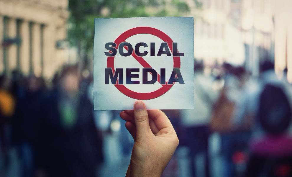 a person holding a placard depicting a social media ban
