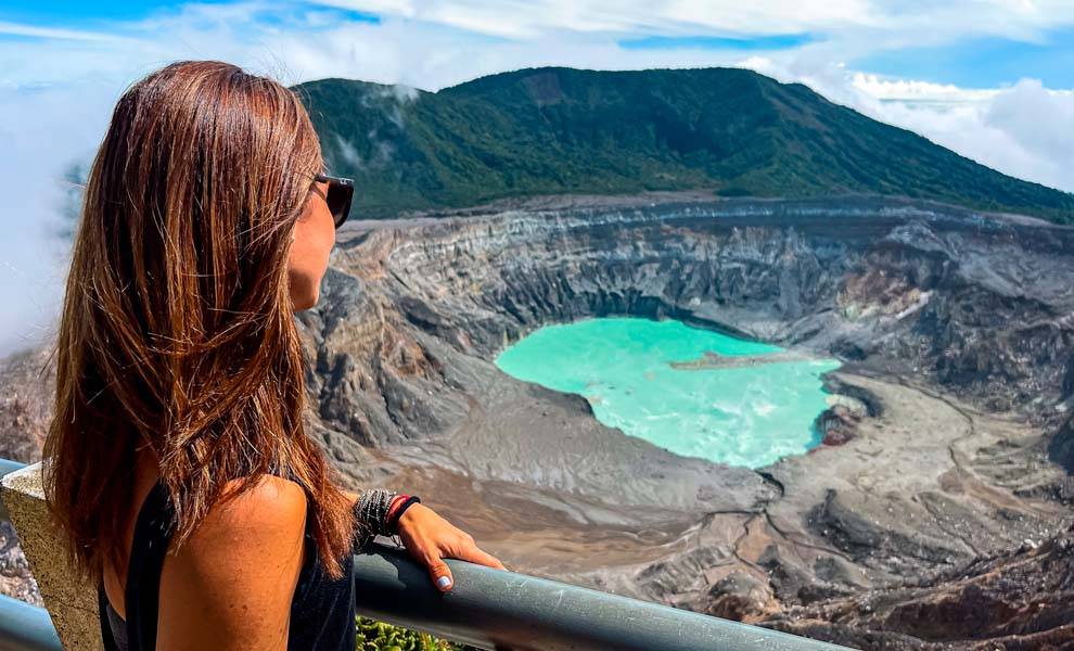 A woman observing a crater within a volcano, captivated by the natural wonder and beauty it holds.
