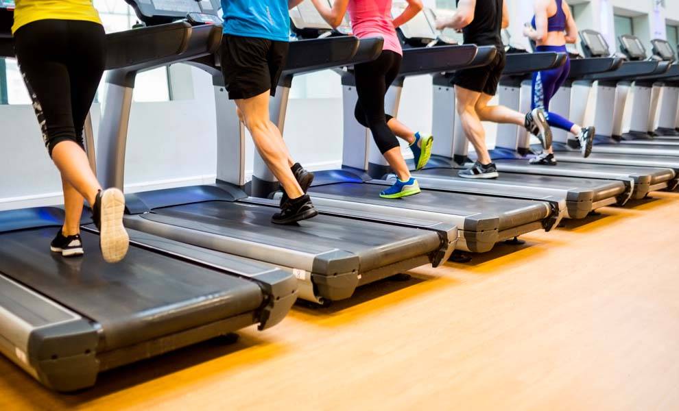 Group of people exercising on treadmills at the gym.