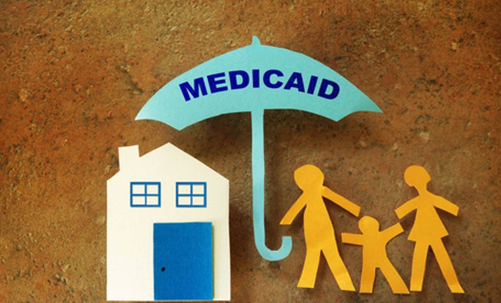 Paper cutout of a family under an umbrella that reads “Medicaid.”