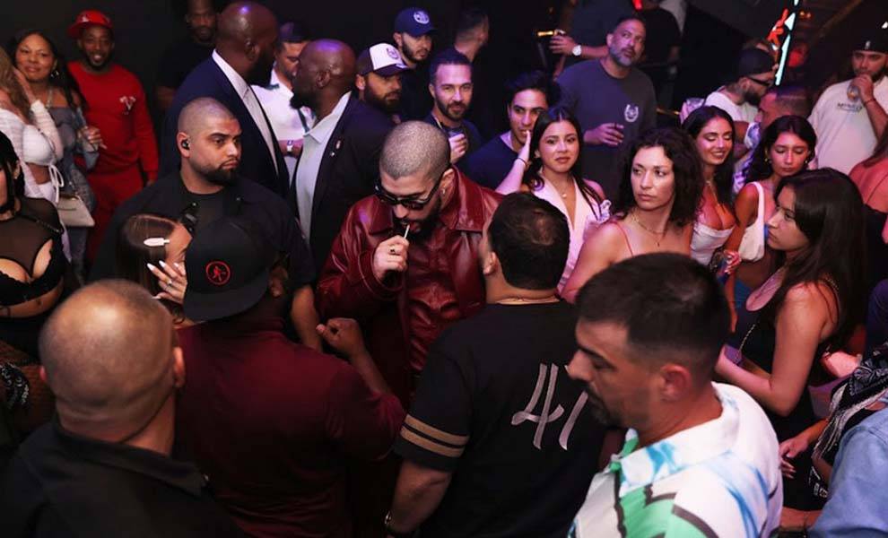 A diverse group of partygoers enjoying themselves, with a man in a black shirt standing out in the crowd.