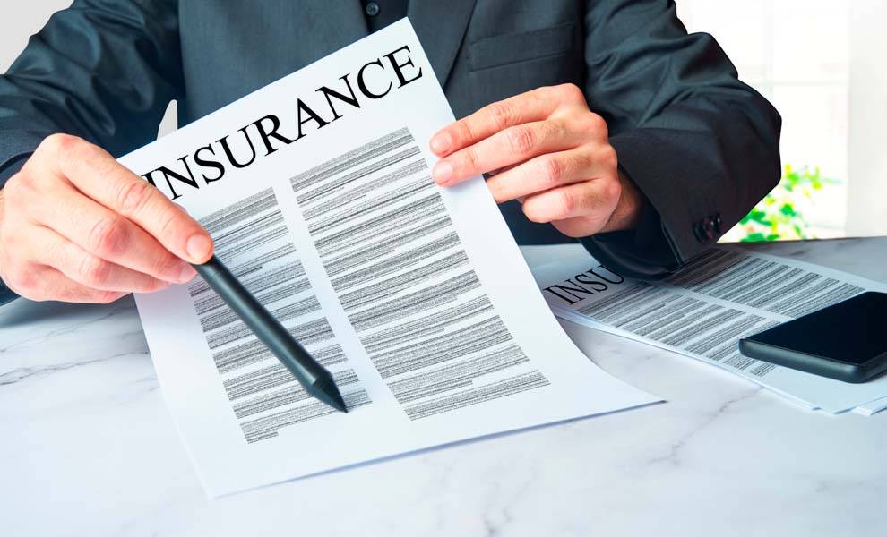 Insurance businessman holding a pencil and paper with the word insurance written on it.