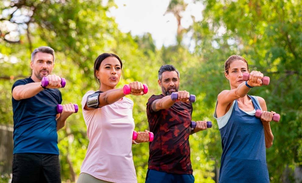 Group of people lifting dumbbells during a fitness class.
