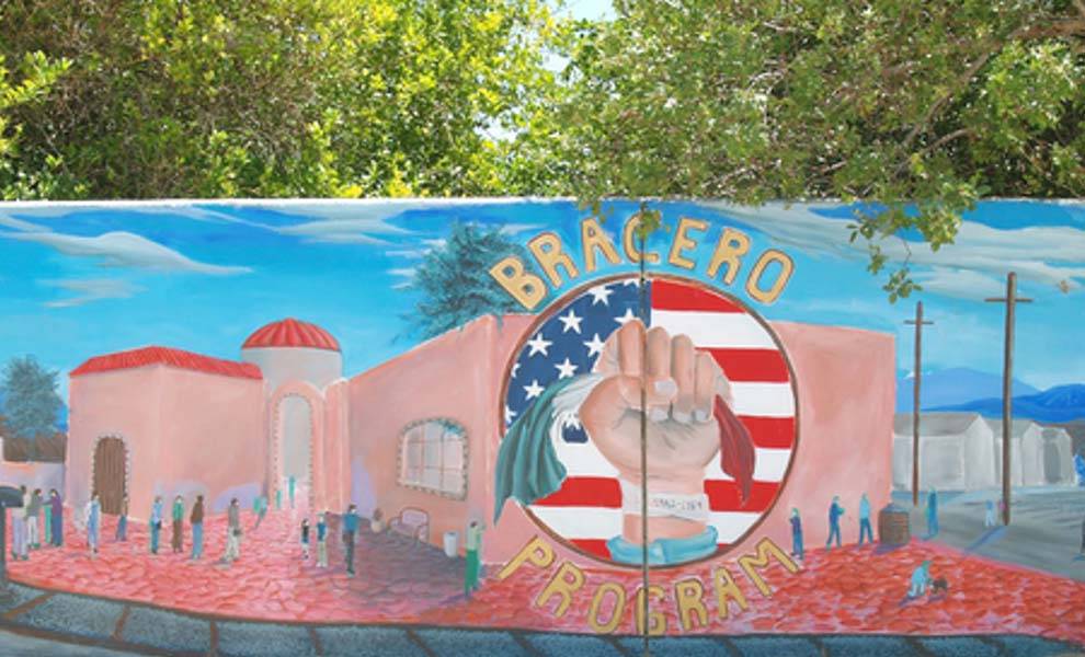 A mural of a woman proudly holding a flag and extending her hand in a powerful gesture.