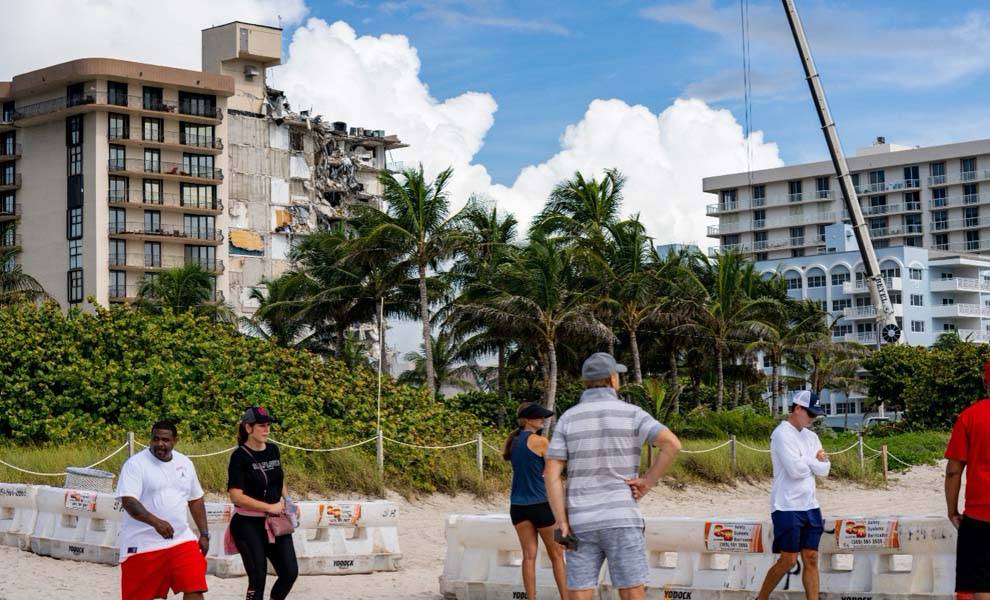 People standing on beach near building.