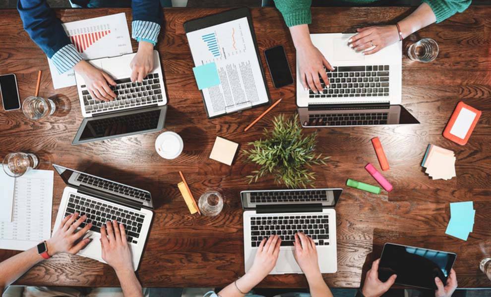 Vista aérea de personas que trabajan con portátiles en un espacio de coworking