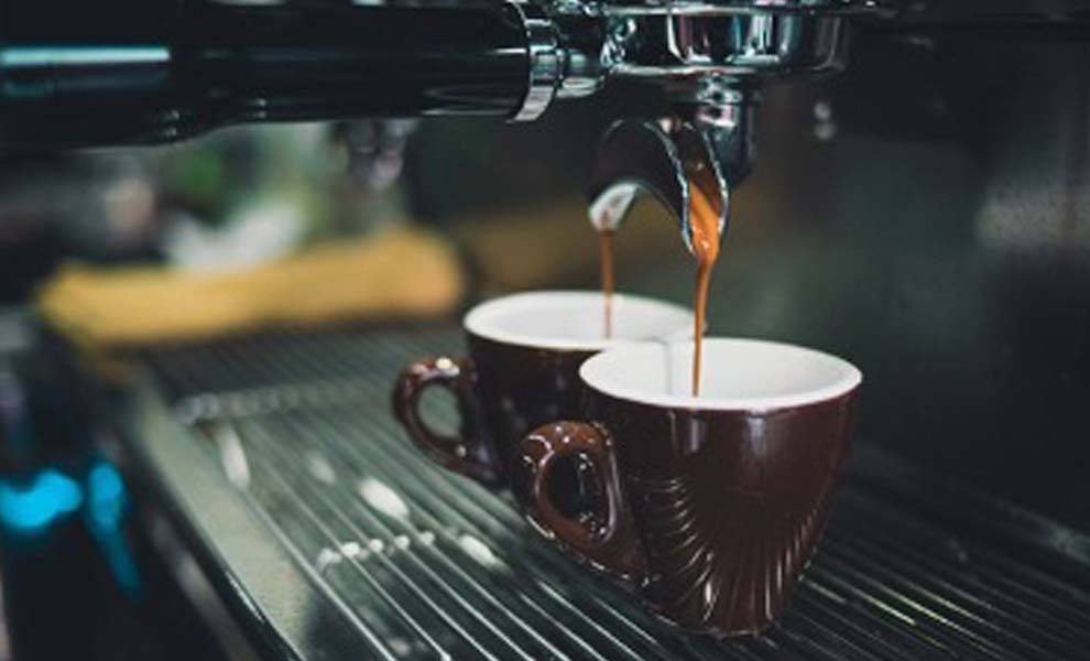 Se vierten dos tazas de café en una máquina, creando una bebida rica y aromática.