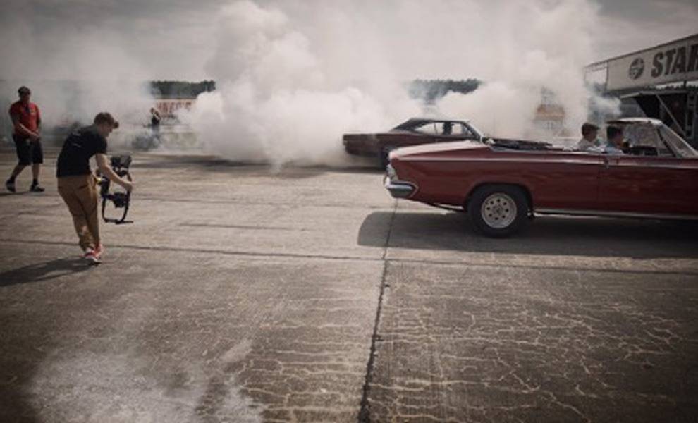A man captures on camera a car being pulled by billowing smoke.