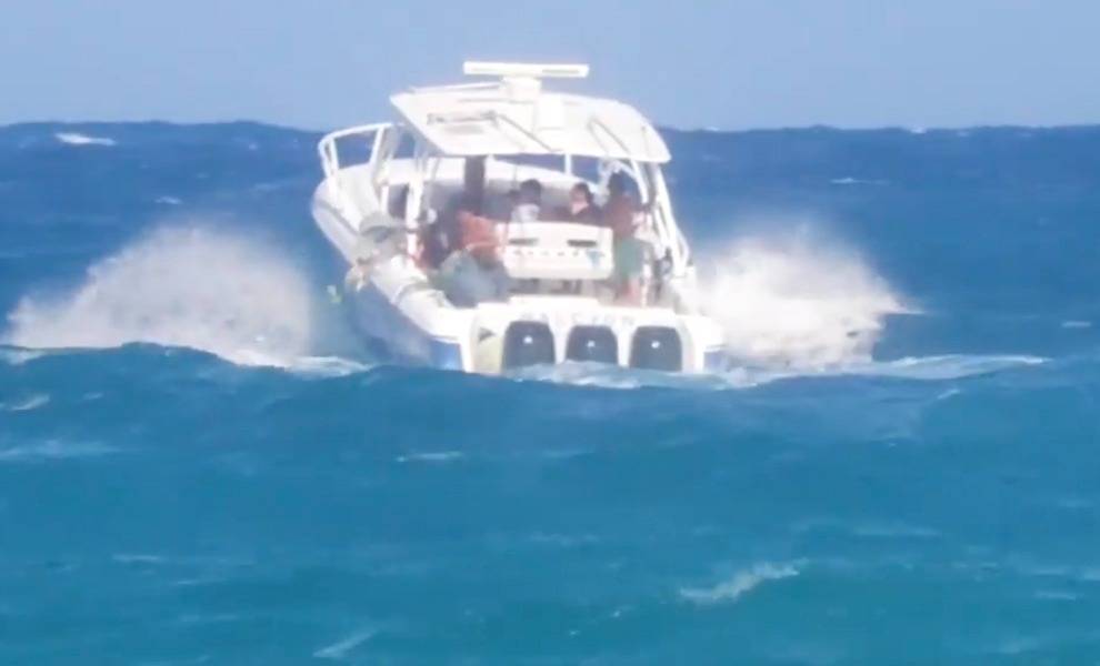 A boat with people on it sailing through the ocean, creating a picturesque scene of adventure and exploration.