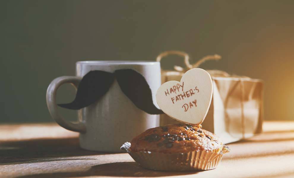 Un muffin en forma de corazón y una taza colocada sobre una mesa.