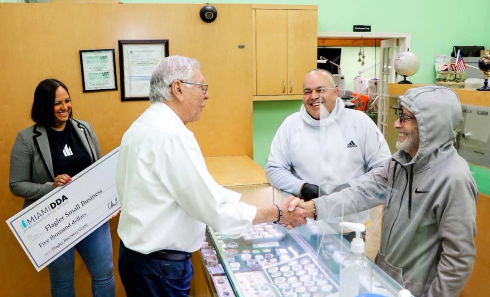 City Commissioner and Miami DDA Chairman Manolo Reyes shaking hands with a business owner.
