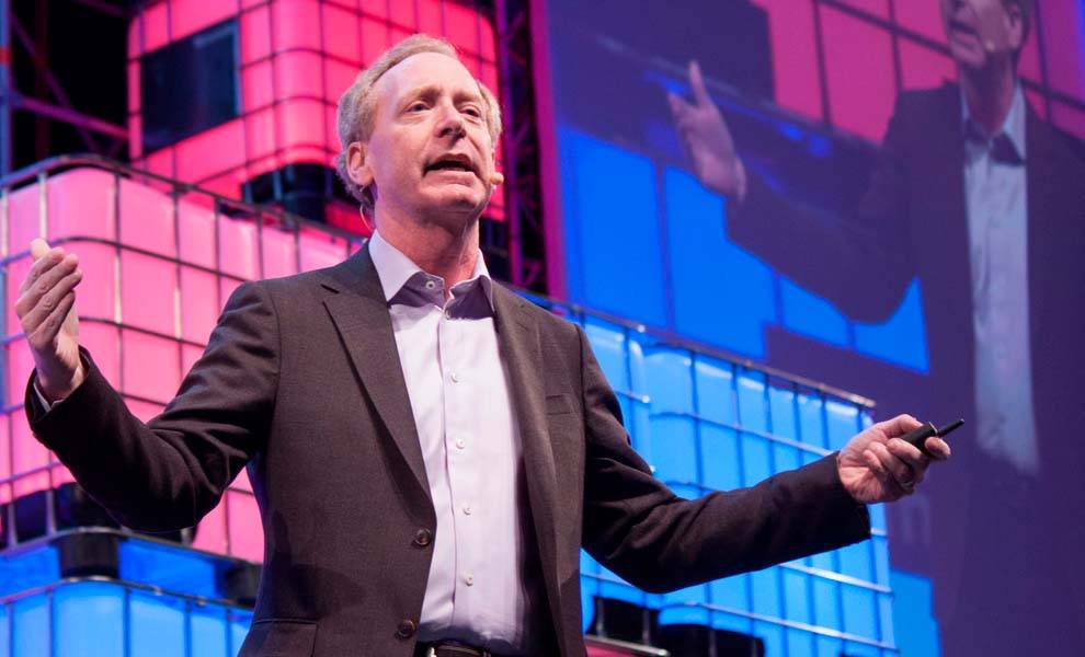 Un hombre de traje dando un discurso en el escenario de una conferencia.