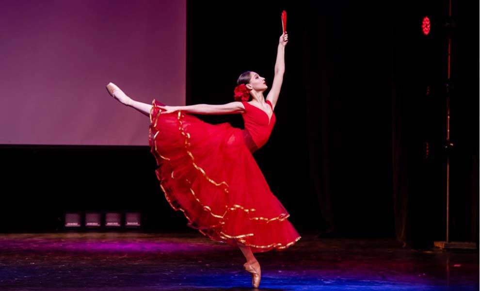 Una mujer con un vestido rojo cantando en el escenario.
