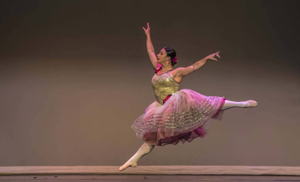 A sparkling soiree launches the XXIX Annual International Ballet Festival of Miami 1 A ballerina gracefully poses in a pink tutu and gold skirt, showcasing elegance and beauty.