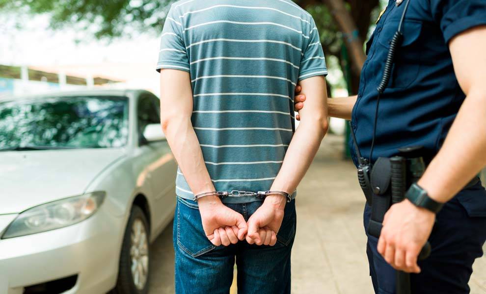 Un hombre detenido por un policía.