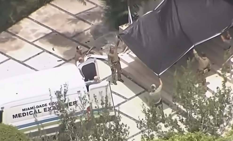 Hombre parado en una camioneta con lona negra.