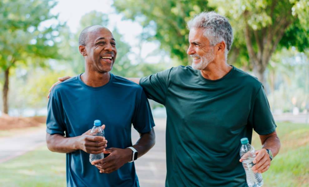 Dos hombres sonriendo y sosteniendo botellas de agua.