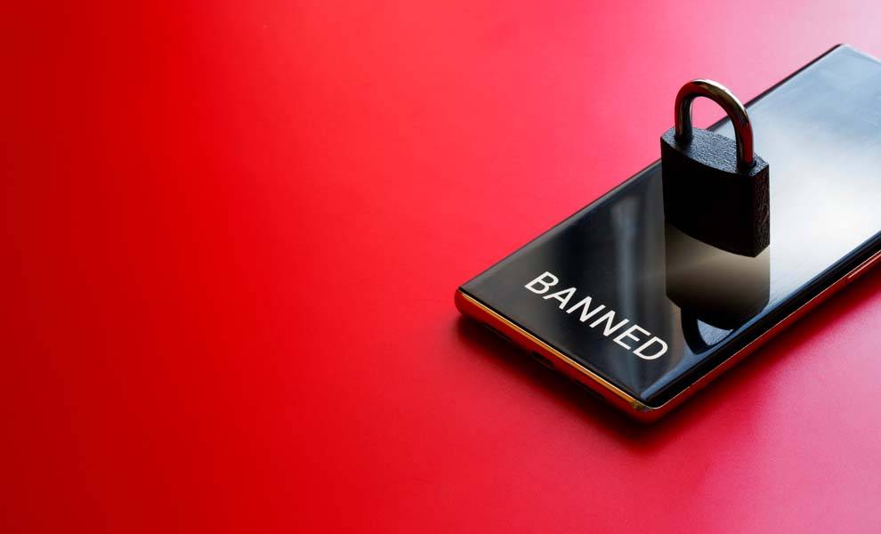 Una persona sostiene un teléfono inteligente con un ícono de candado en la pantalla, que simboliza la protección del teléfono para evitar el bloqueo.