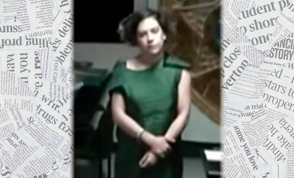 A woman in green vest and handcuffs in the courthouse.