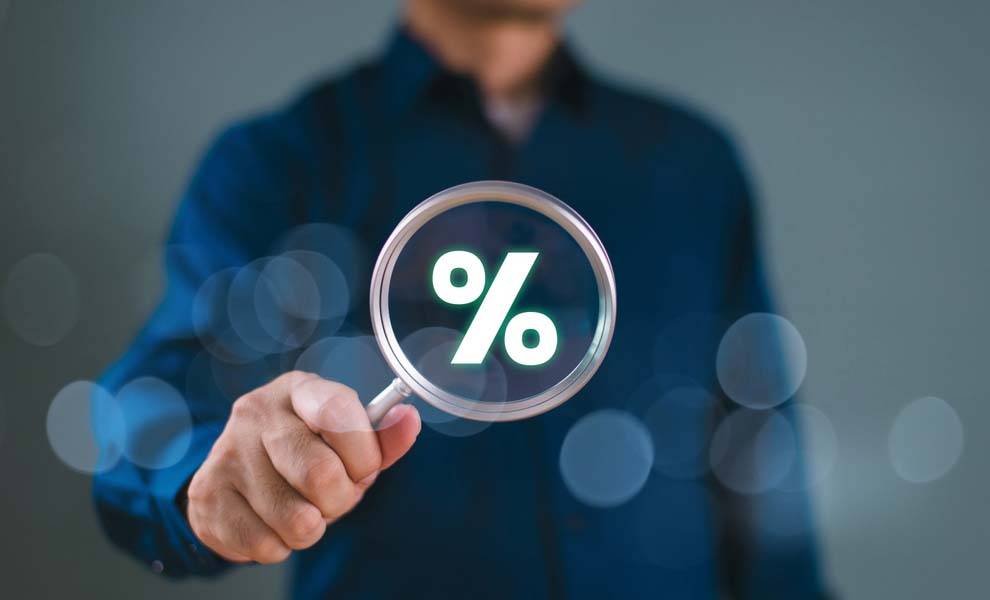 Un hombre sosteniendo una lupa con el signo %.