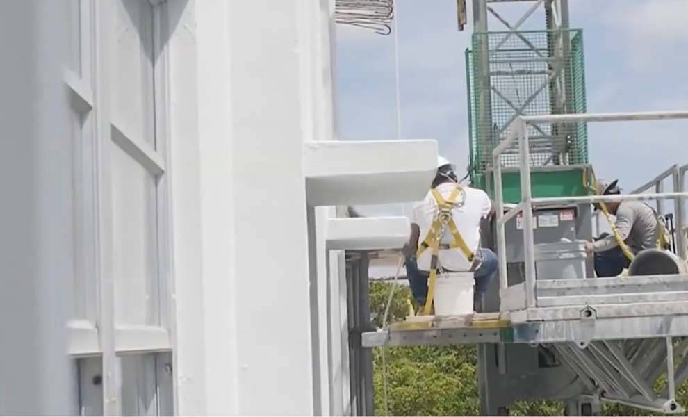 Dos trabajadores de la construcción en un condominio en Aventura trabajando arreglando un balcón.