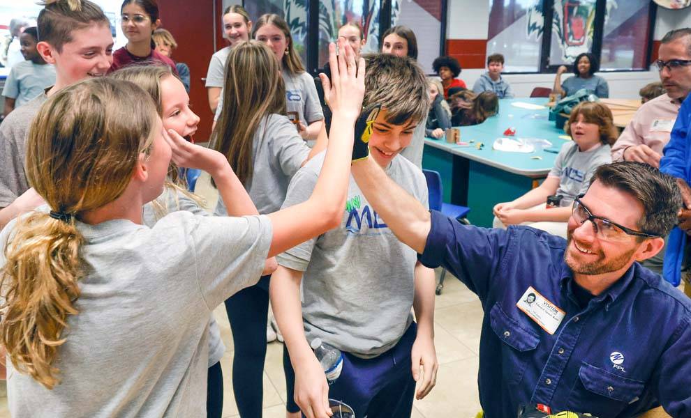 Niños en un aula con empleados de FPL.