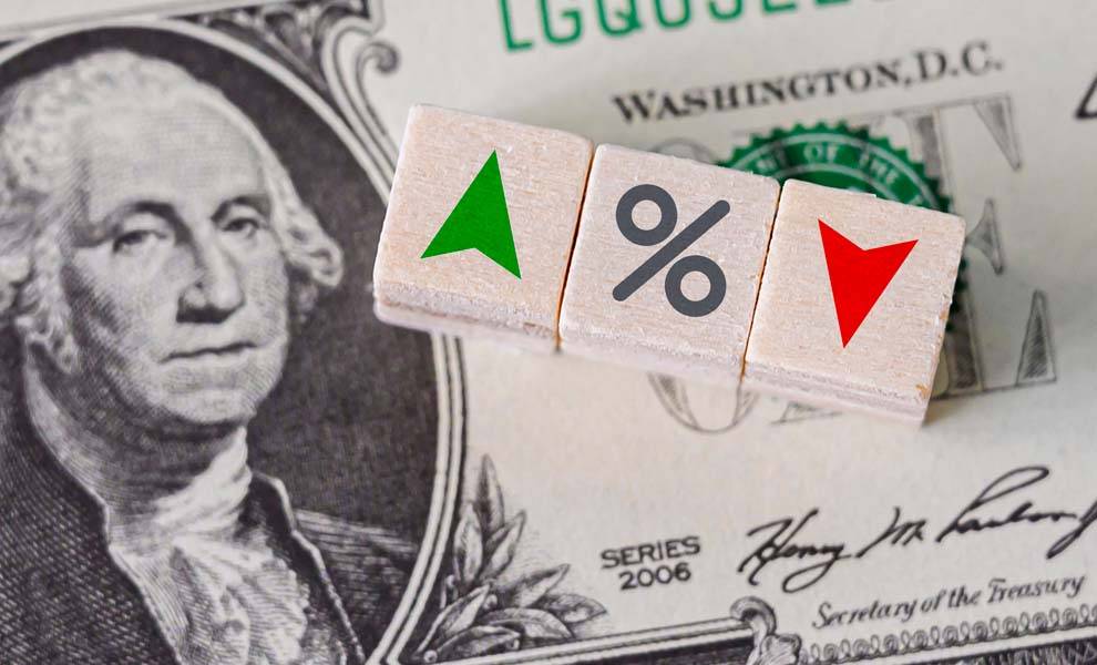 Flechas verdes y rojas con un signo de porcentaje en el centro y dinero en el fondo.