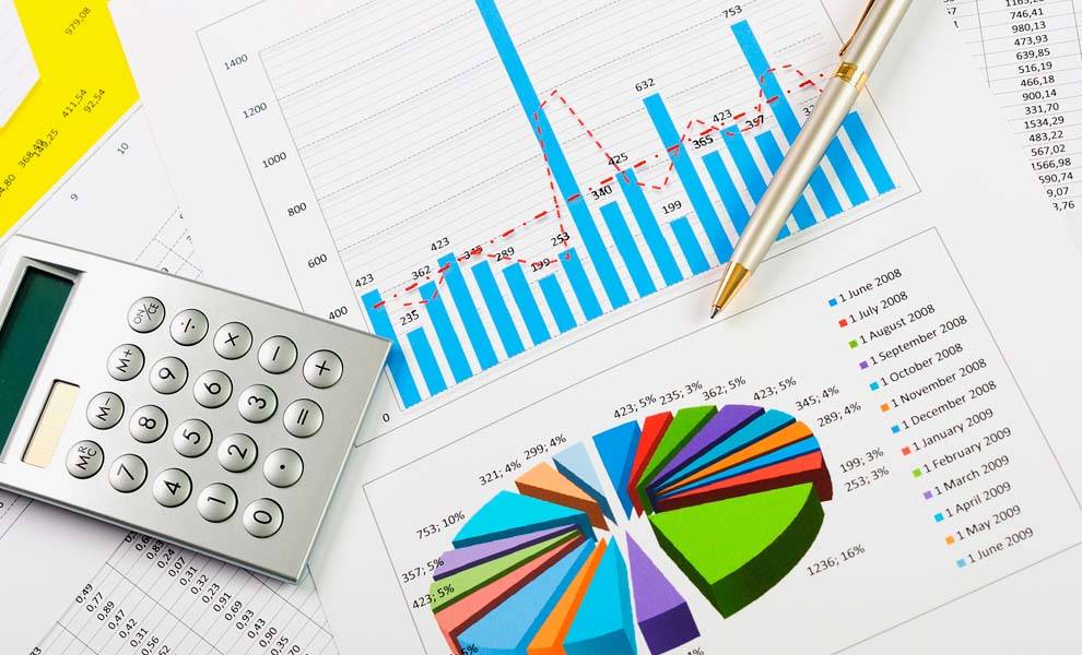 Colorful spreadsheets, a pen, and a calculator.