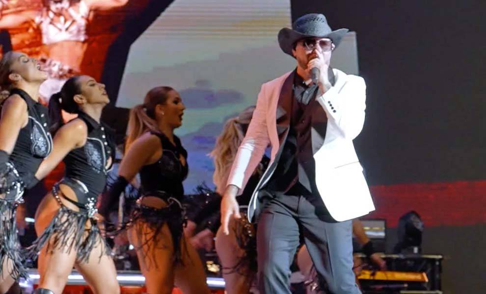 Pitbull on stage with cowboy hat performing.