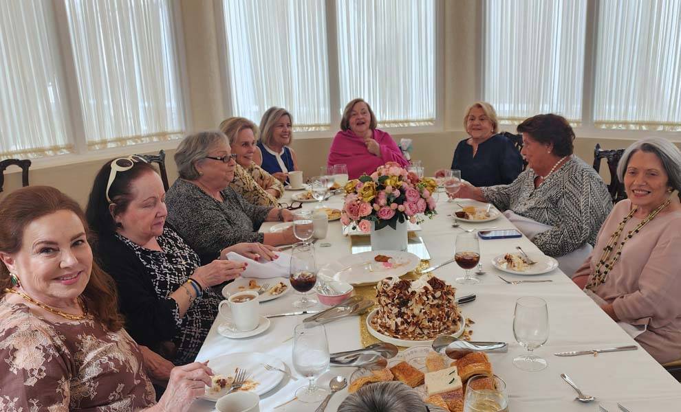 A group of women gathered around a table, enjoying a meal together in a warm and inviting setting.