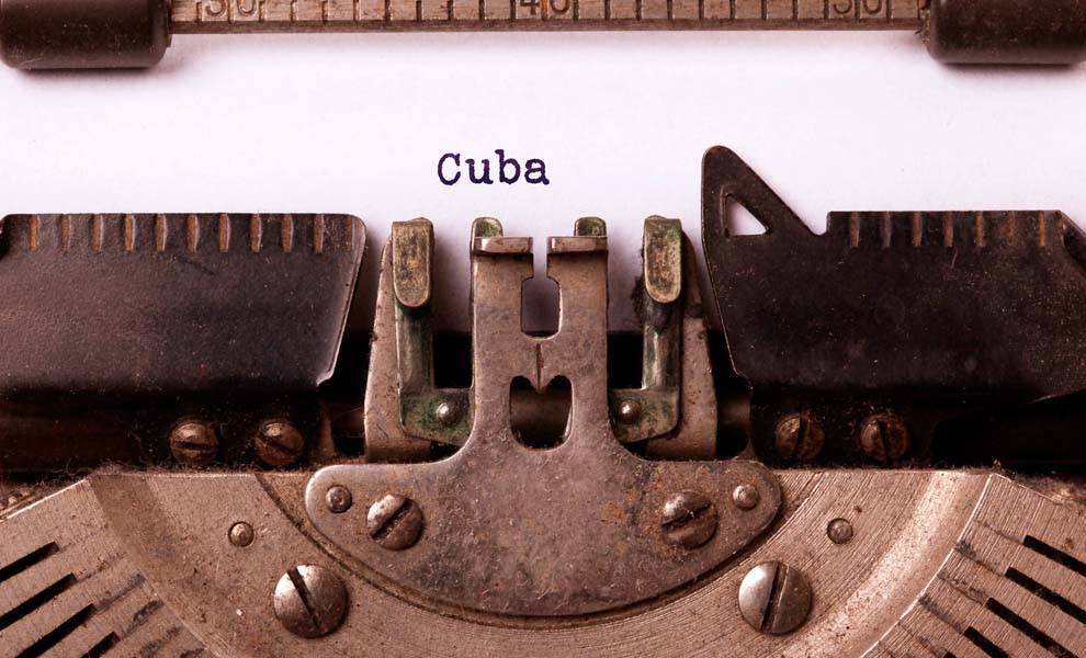Una máquina de escribir antigua con una hoja de papel y la palabra Cuba escrita.