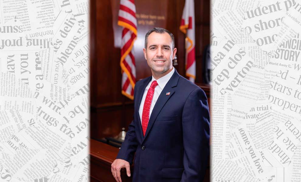 Miami-Dade Clerk of the Court in a suit and tie stands confidently.