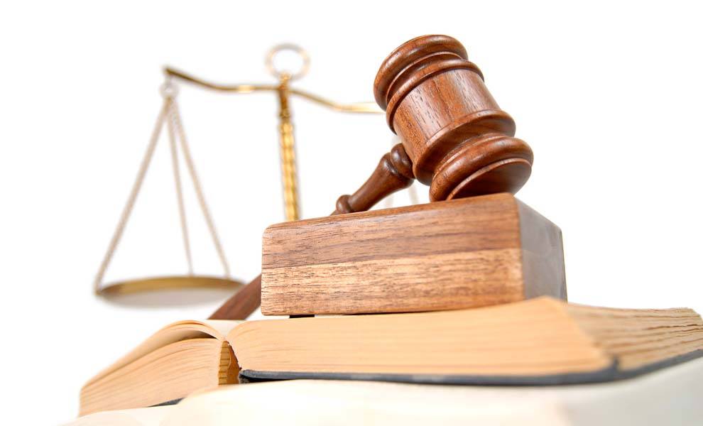 Una representación simbólica de la ley y la justicia, con balanza, un mazo y libros legales.