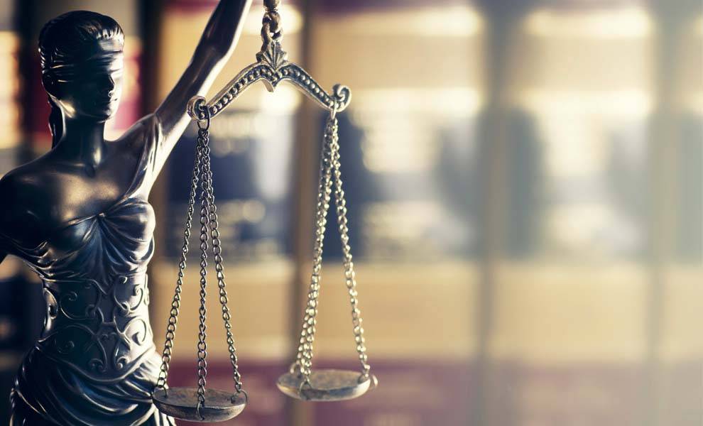 A statue of Lady Justice, blindfolded, holding scales, symbolizing fairness and the rule of law.