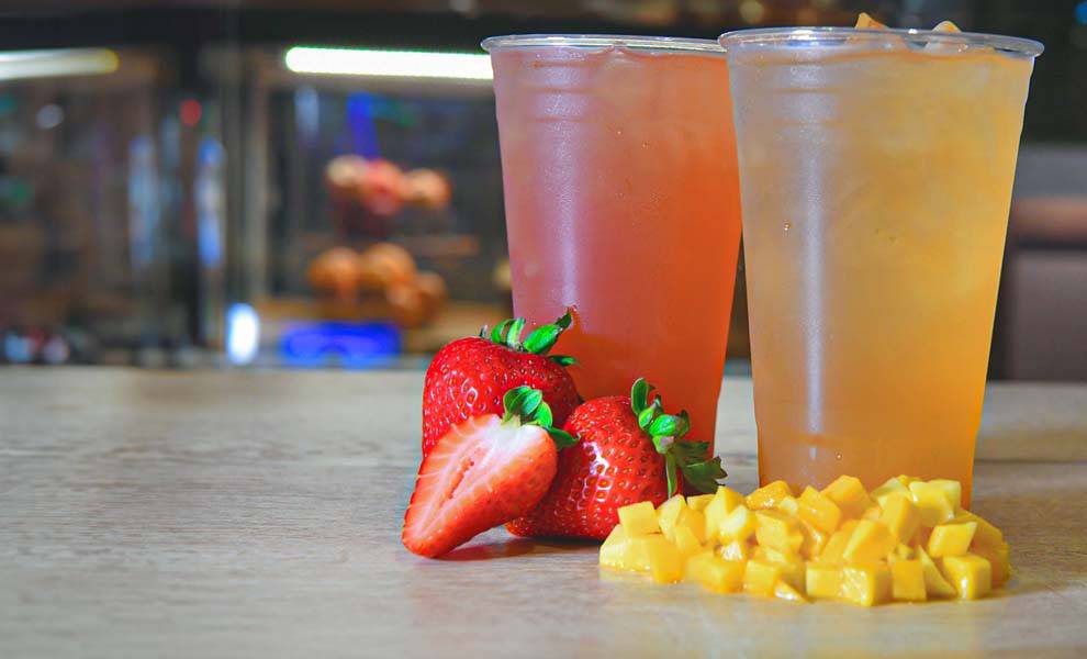 A vibrant strawberry and a ripe mango displayed together, showcasing their rich colors and textures.