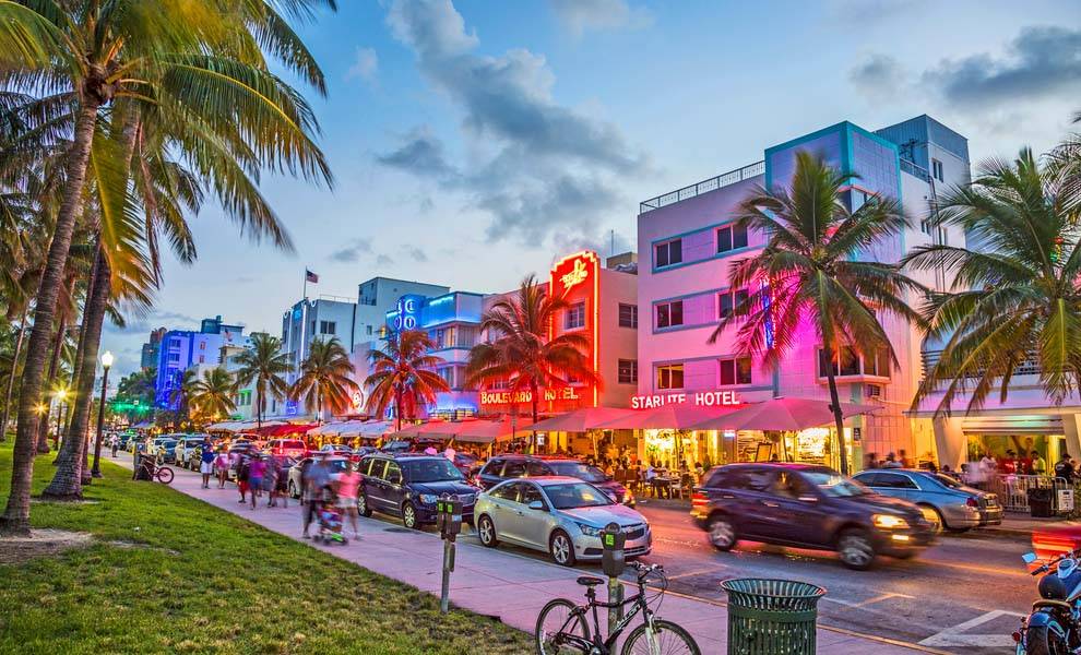 Una vista vibrante de Miami Beach, que muestra su icónica costa y su animada atmósfera bajo un cielo azul claro.